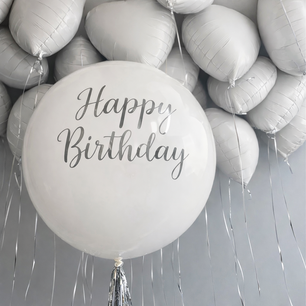 White balloon with 'Happy Birthday' text among heart shaped balloons