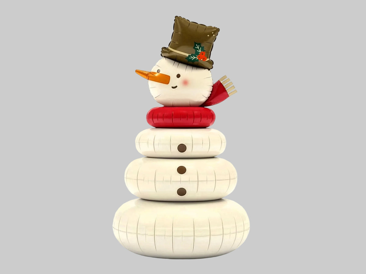 The Frosty Edit giant standing Christmas snowman foil balloon featuring a cheerful snowman with a festive top hat, red scarf and white rounded body, displayed beside a Christmas tree.