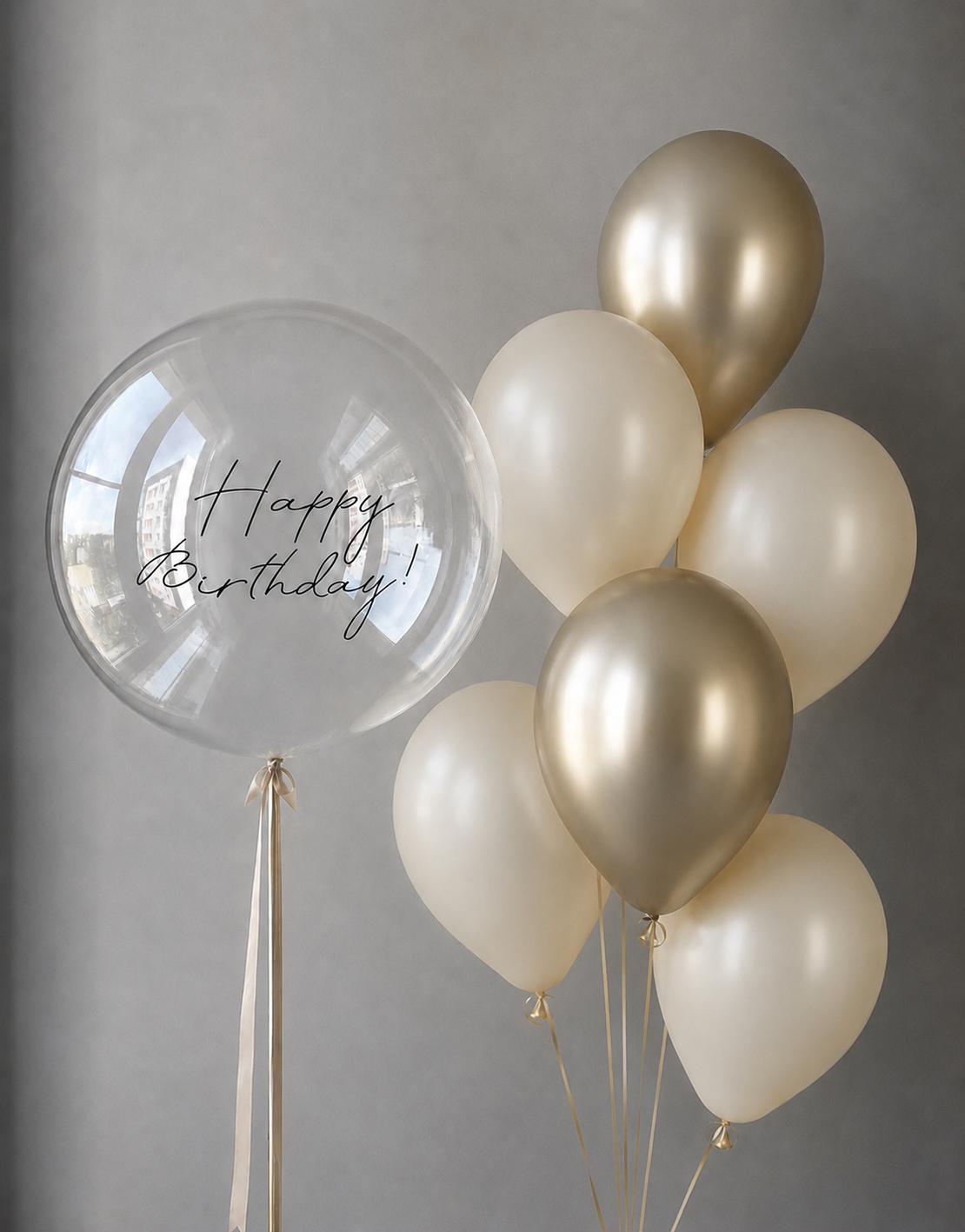 Personalised clear bubble balloon paired with ivory and pearl gold helium balloons in an elegant birthday bouquet.