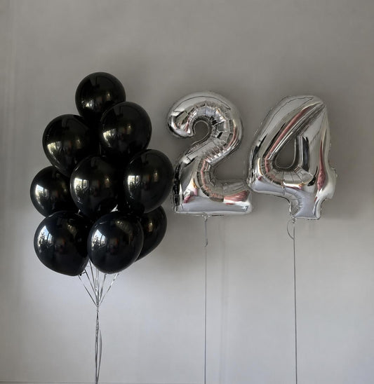 Black latex balloon bouquet with silver number 24 helium balloons on a neutral background.