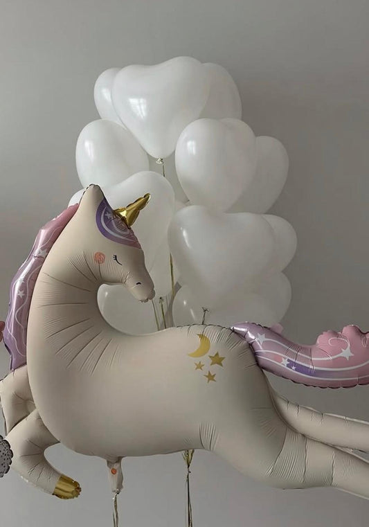 White unicorn foil balloon with pastel pink and lavender accents paired with white helium balloons in a minimal balloon bouquet arrangement.