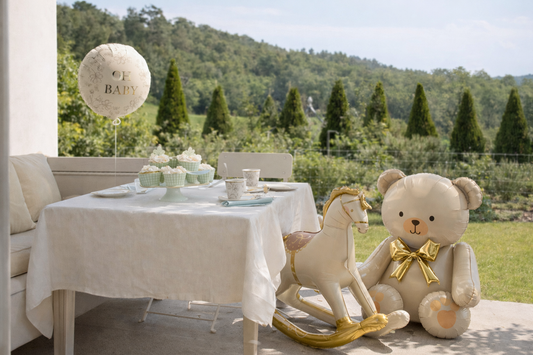 baby birthday setup with bear rocking horse and foil balloon