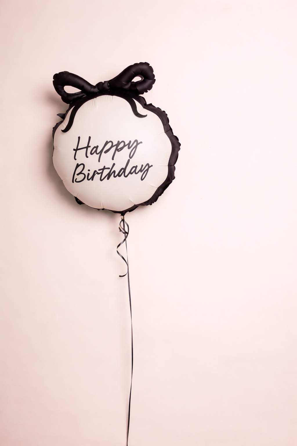 Balloon with 'Happy Birthday' text and black bow.