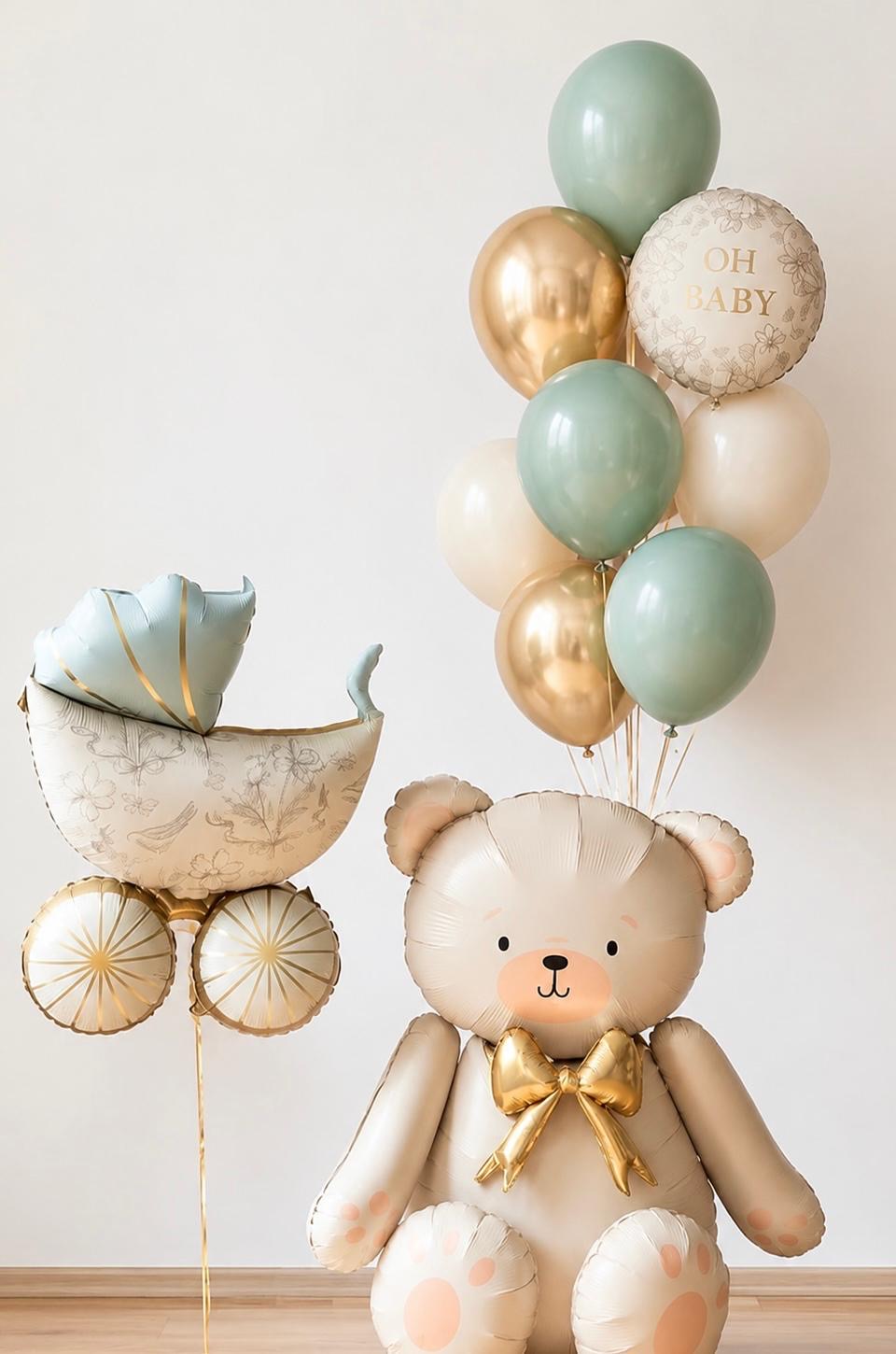The Baby Bear Edit newborn baby balloon arrangement featuring a cream teddy bear, vintage pram and sage green, ivory and gold helium balloons.