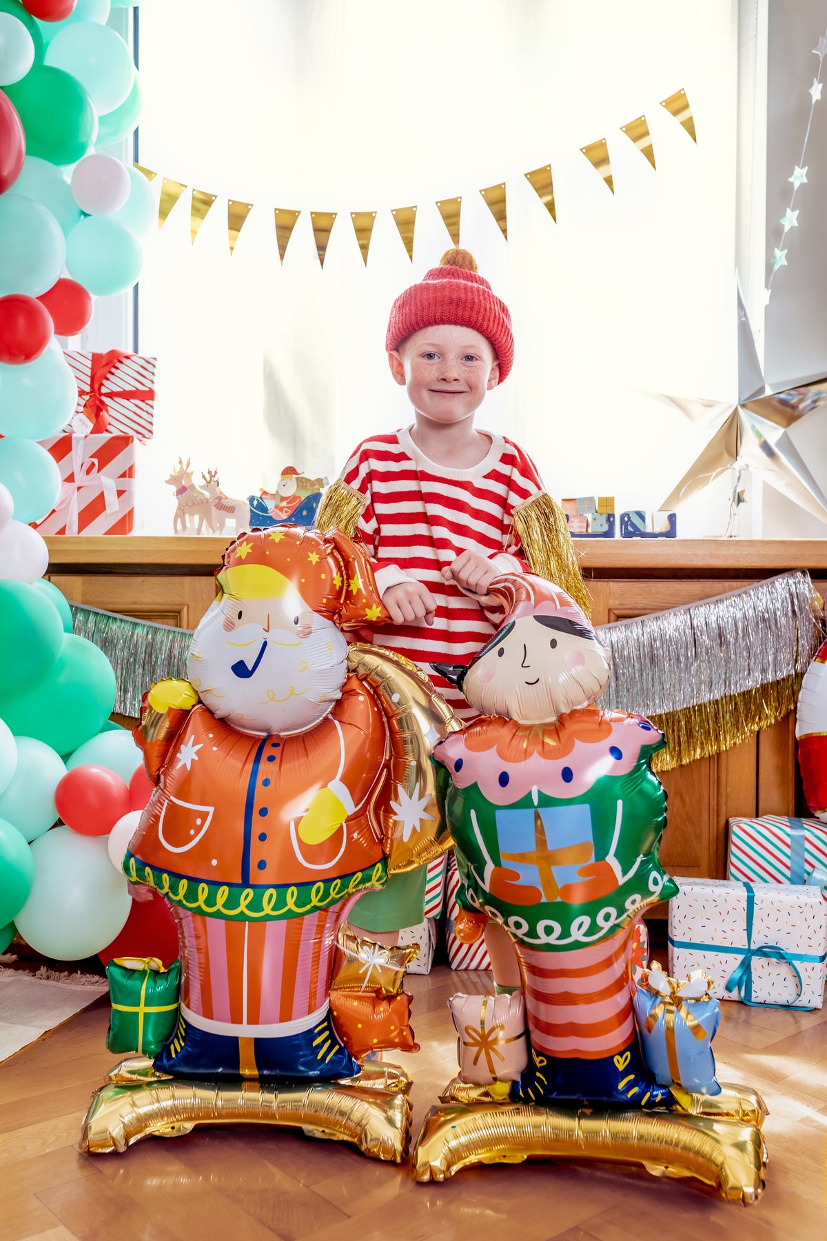 The Christmas Magic Edit featuring colourful standing Santa Claus and Christmas Nutcracker foil balloons displayed in a festive Christmas setting.