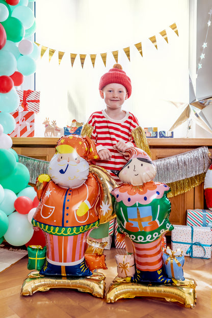 The Christmas Magic Edit featuring colourful standing Santa Claus and Christmas Nutcracker foil balloons displayed in a festive Christmas setting.