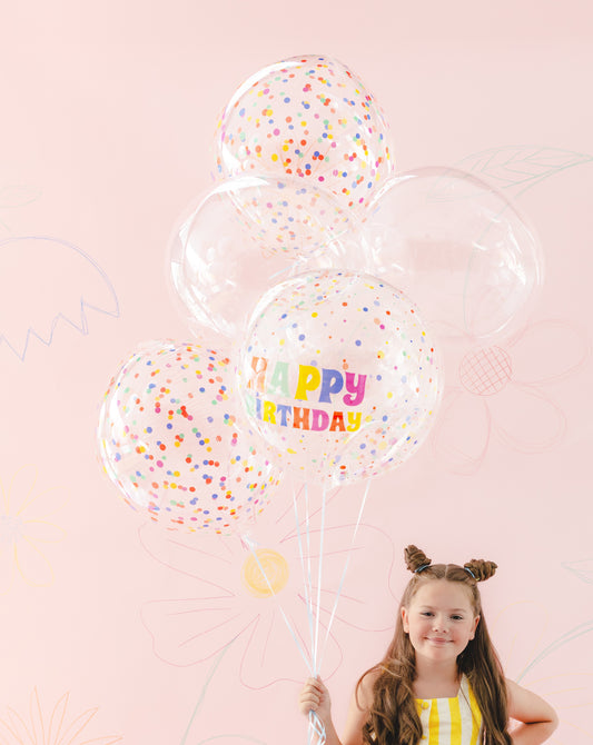 The Confetti Pop Edit helium balloon bouquet featuring a clear Happy Birthday orb balloon with colourful confetti print, two coordinating confetti-print balloons and two crystal-clear balloons.