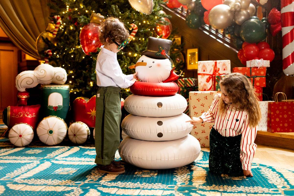 The Frosty Edit XXL Christmas snowman balloon displayed alongside children in a festive Christmas setting, perfect for Christmas parties and holiday decorations.