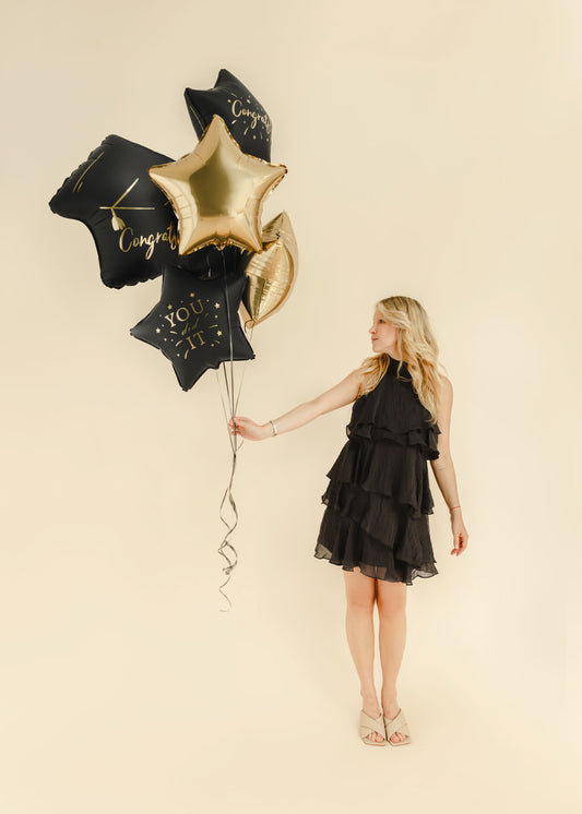 The Graduation Edit helium balloon bouquet featuring a black graduation cap foil balloon, black Congrats and You Did It star balloons, and champagne gold star balloons.