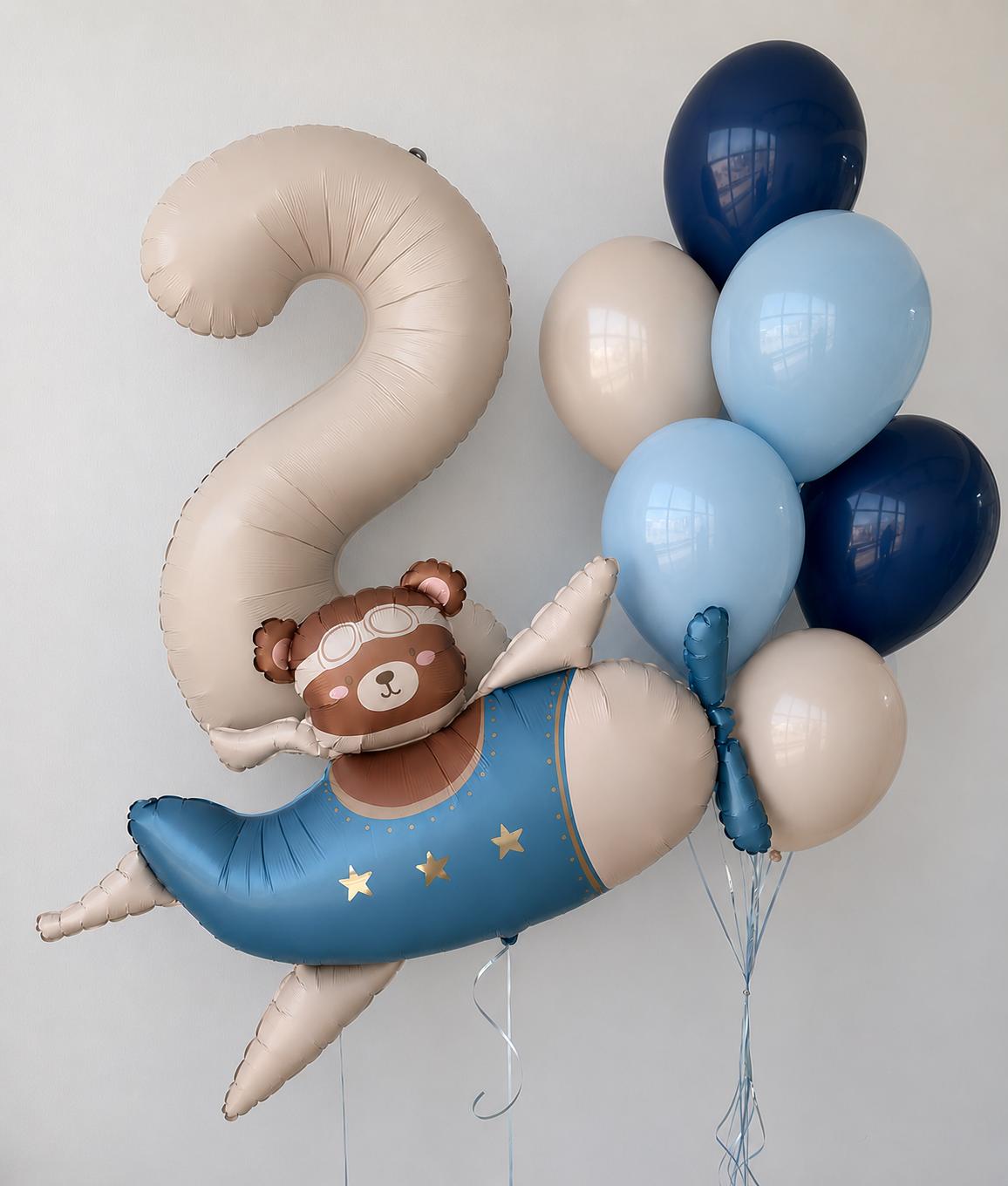 Airplane bear balloon with a large number 2 balloon and blue, navy and ivory helium balloons for a children's birthday celebration.