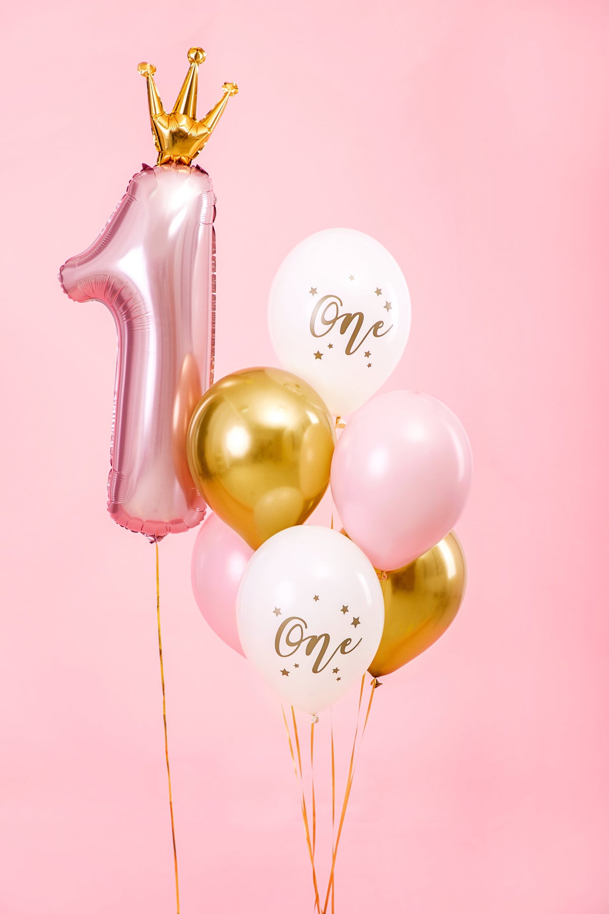 The Little Princess Edit first birthday balloon arrangement featuring a pink number 1 foil balloon with gold crown and coordinating pink, white and gold helium balloons.