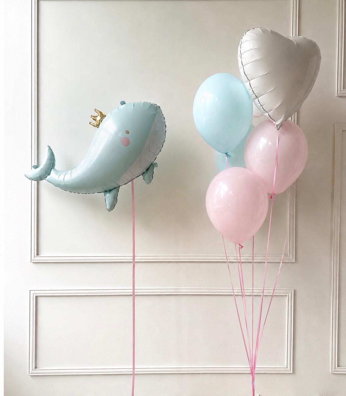 Blue whale balloon with pastel blue and pink helium balloons and a white heart balloon, styled for a baby shower or newborn celebration.